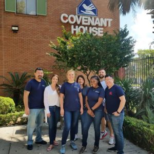 Seven smiling visitors at the Covenant House.